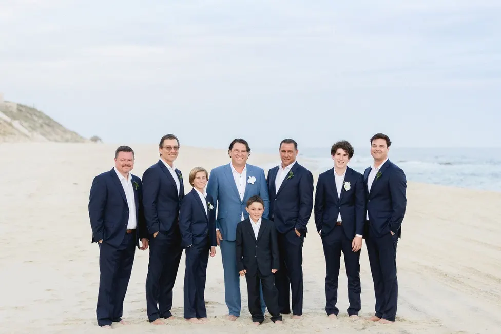 Wedding party in coordinated custom suits on the beach