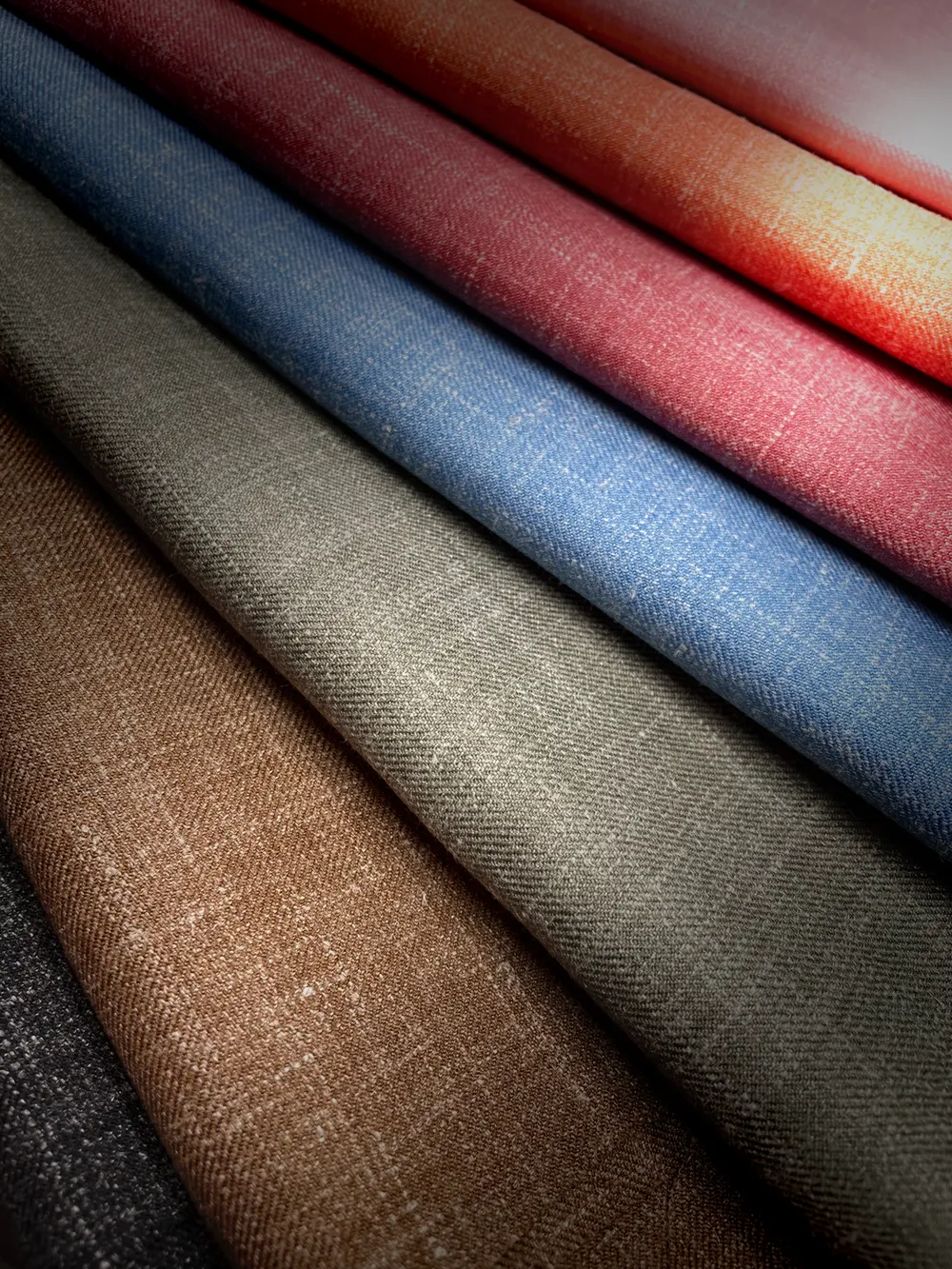 Stack of suiting fabrics in a range of colors